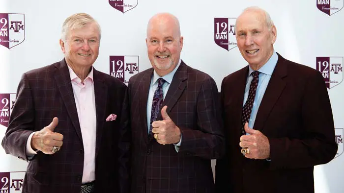 three men posing with thumbs up