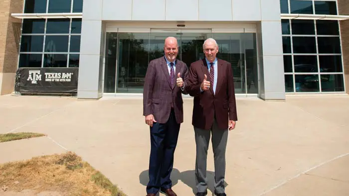 two men posing with thumbs up