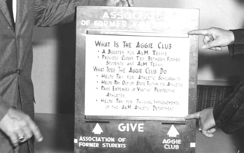 Black and white photo of hands pointing to a sign