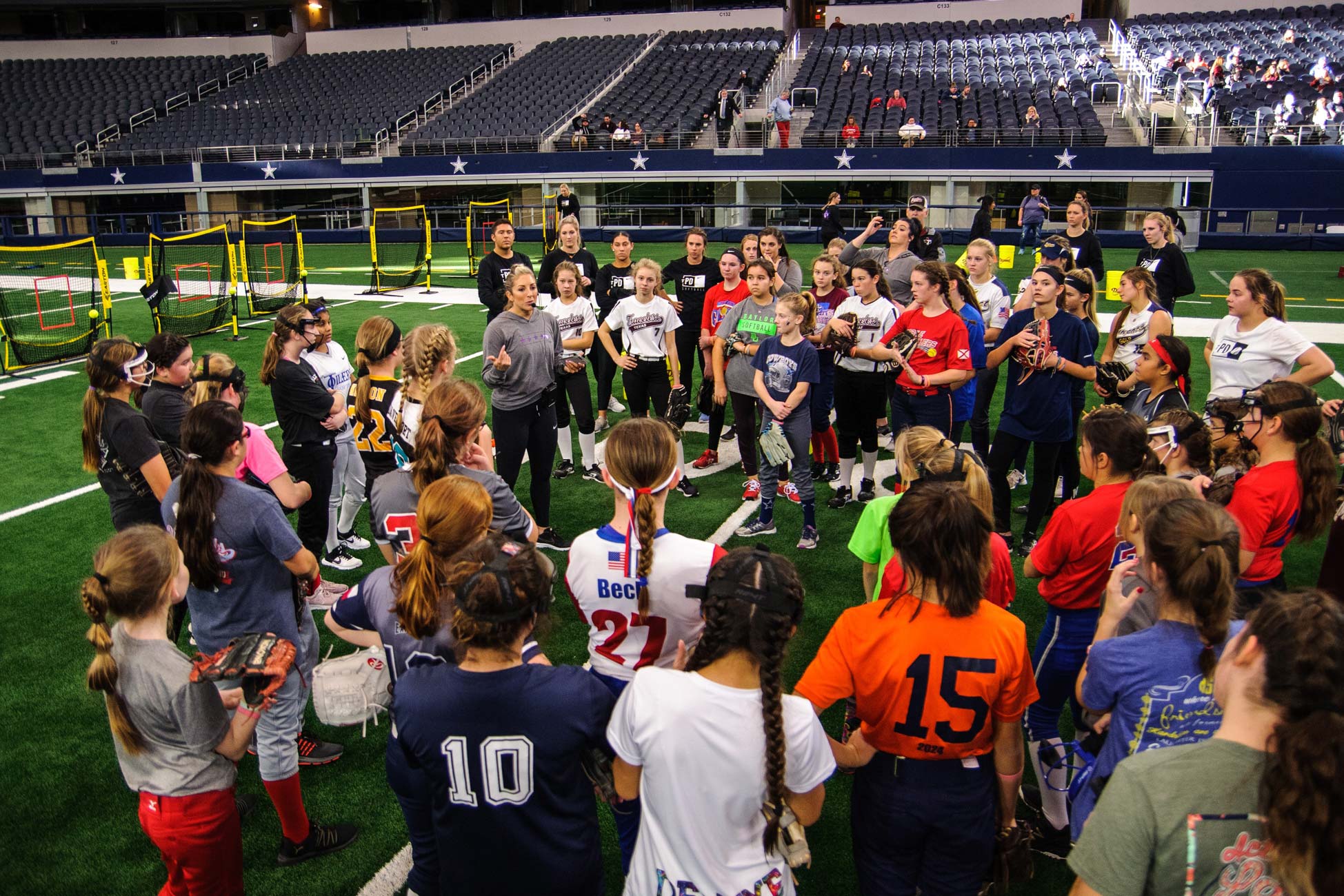Amanda Scarborough speaking to a group of softball players on the field