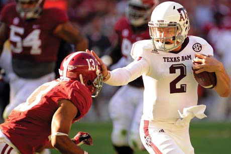 Aggie football player stiff-arming an opposing player