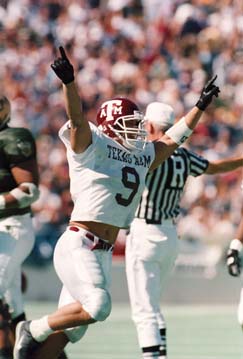 Football player with his arms up celebrating on the field