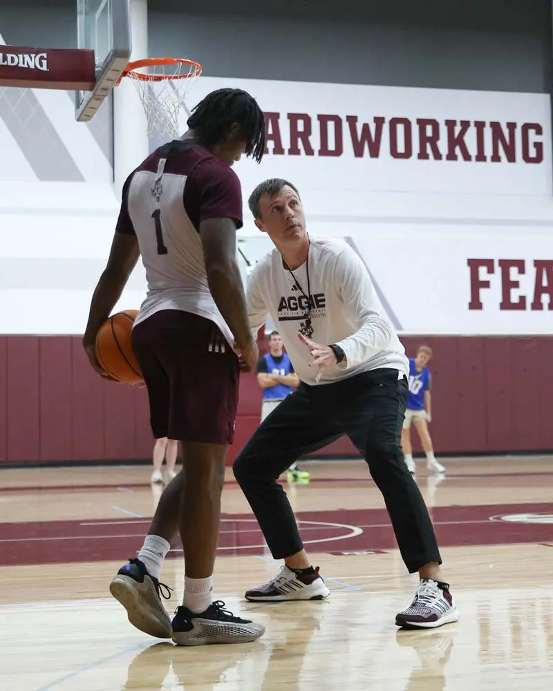 Bucky McMillan coaching a player on the court