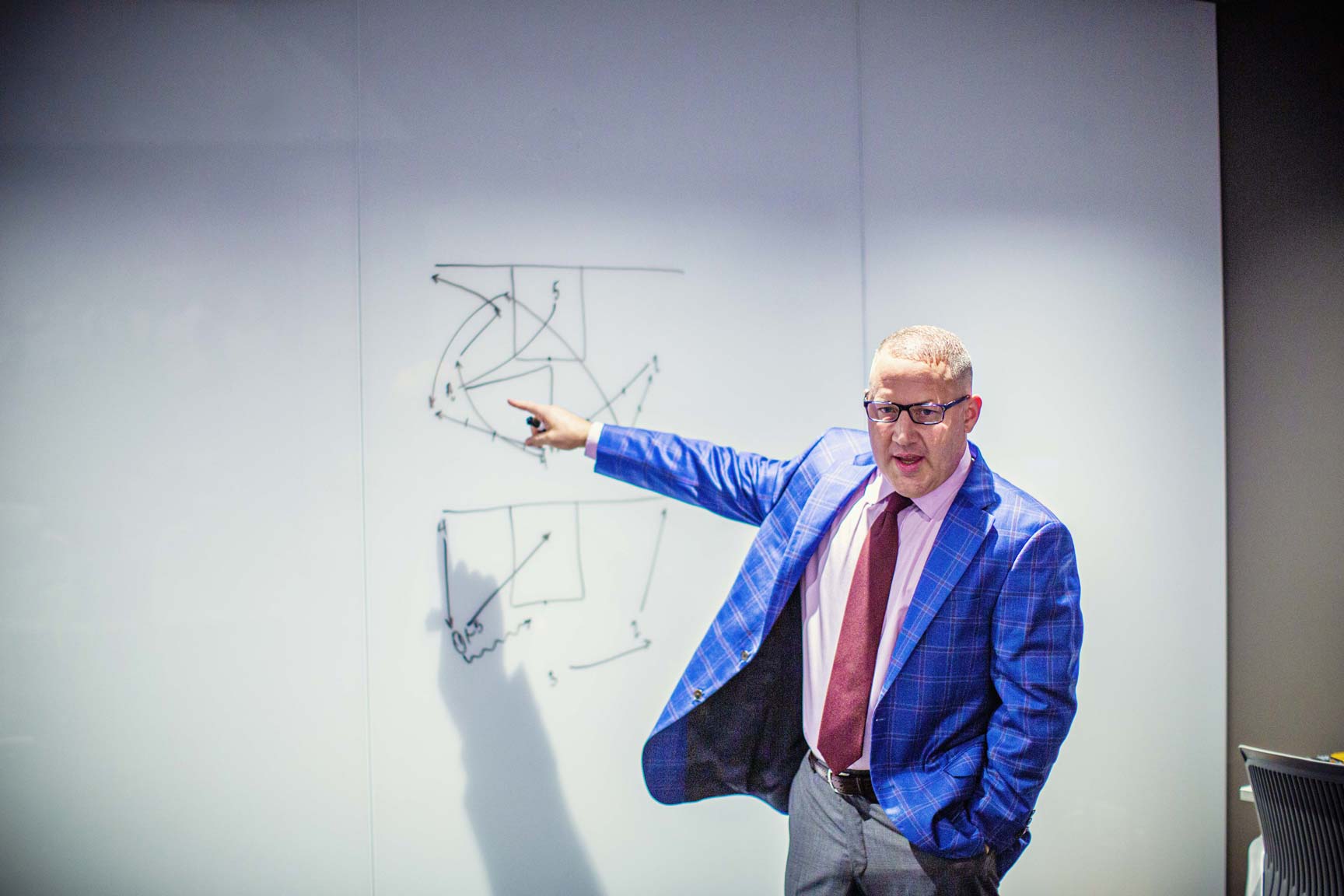 Buzz Williams pointing a play on the white board