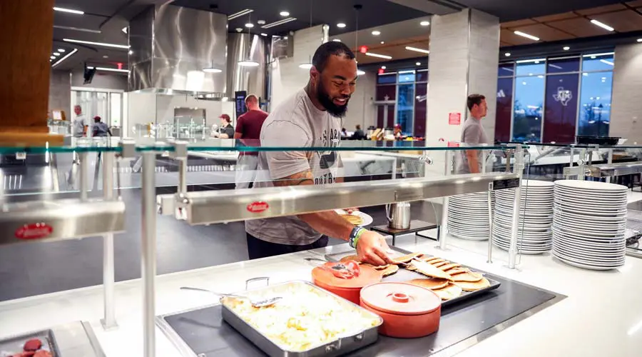 Shot of student athlete serving himself food
