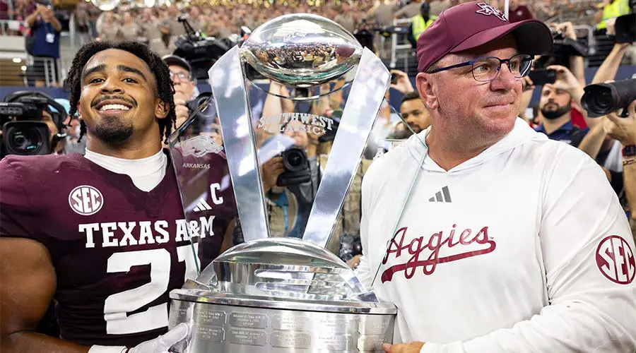 Taurean York holding trophy with a coach