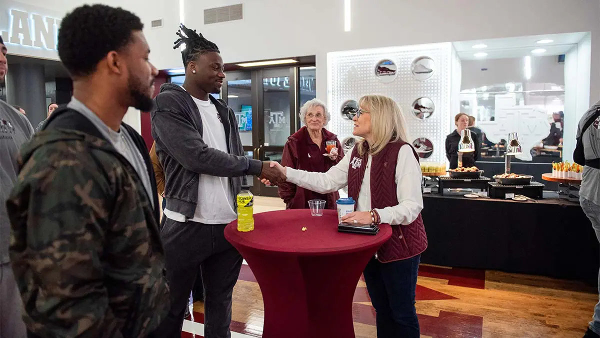 student-athletes shaking hands with women