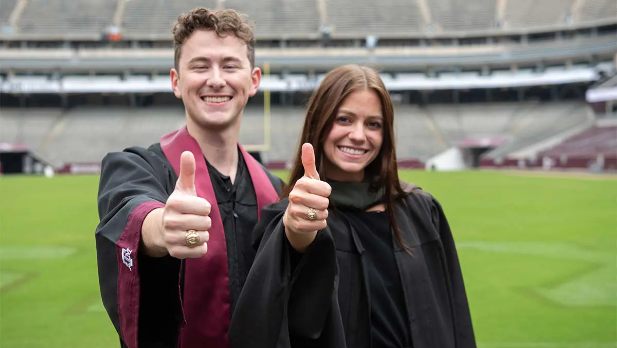 graduates giving thumbs up